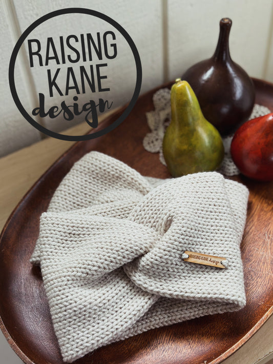 Knitted product with a brand tag on a wooden surface, featuring 'Raising Kane Design'.