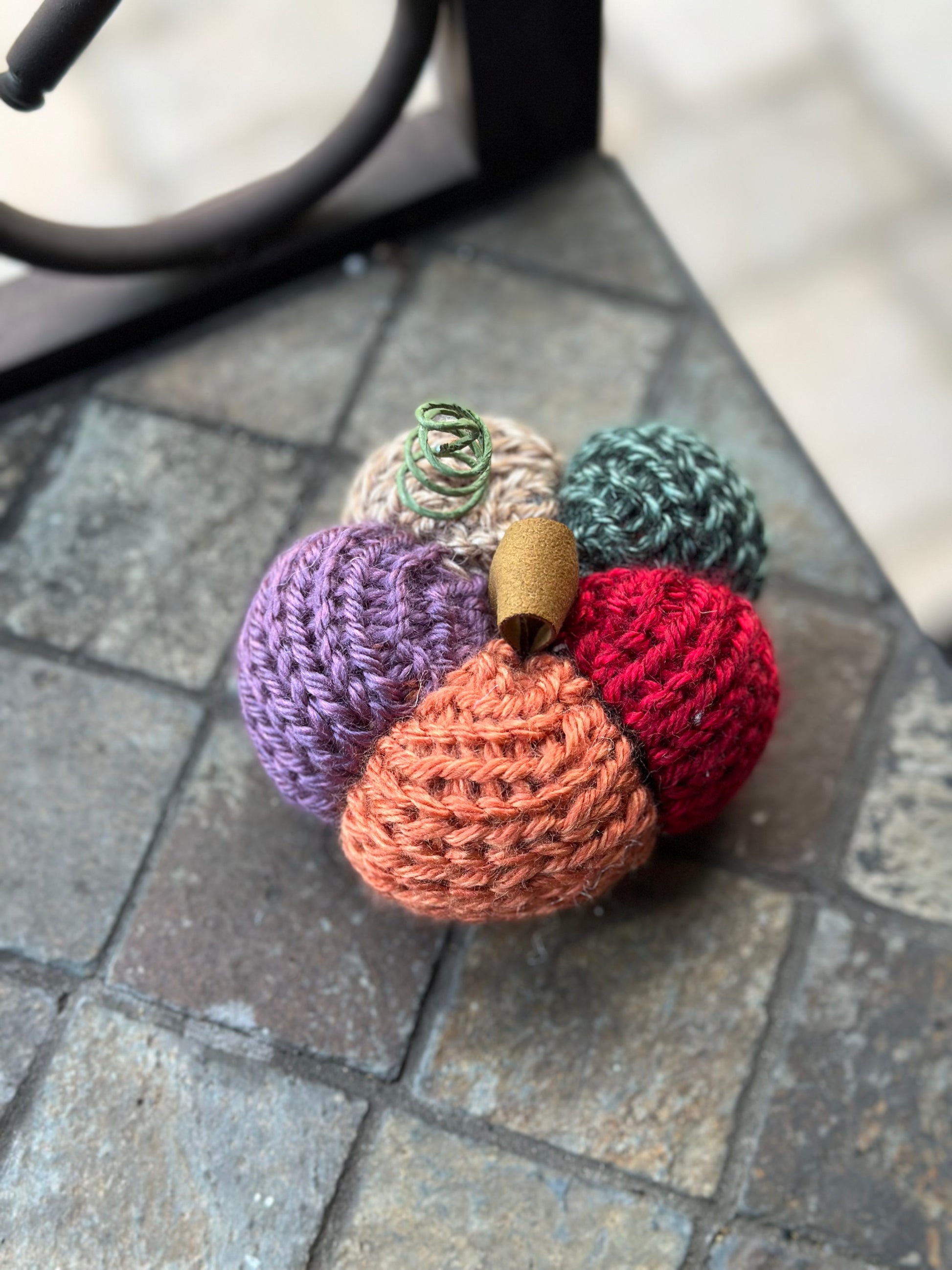 Colorful knit daily-shaped pumpkin on a stone surface