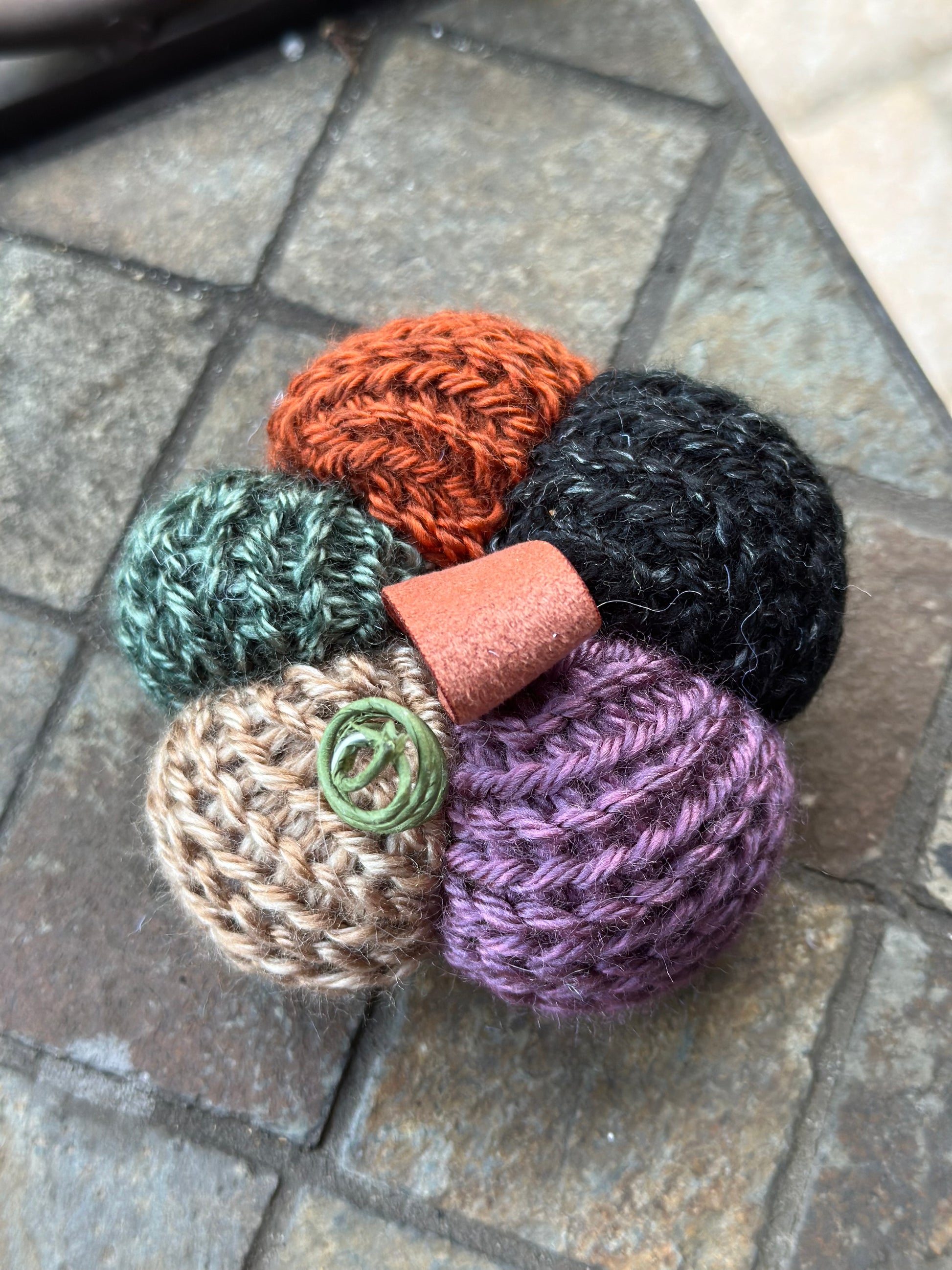 colorful knitted pumpkin on a stone surface