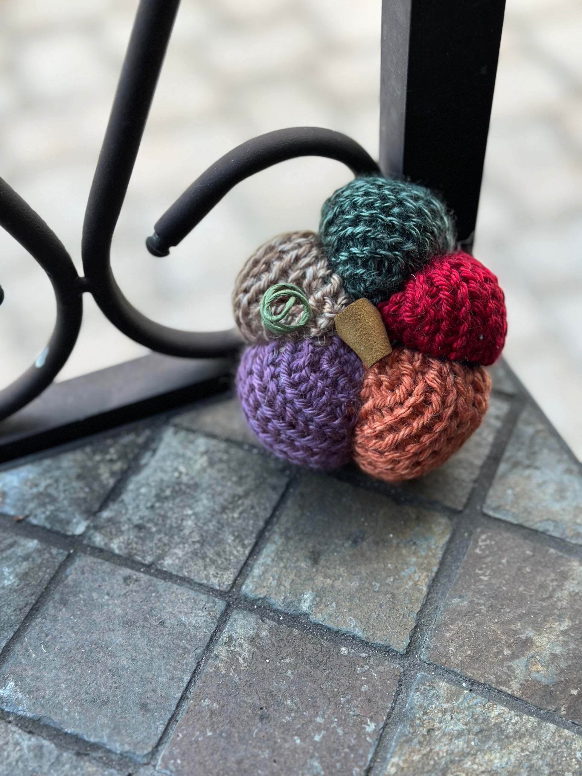 Colorful knit pumpkin on a stone surface